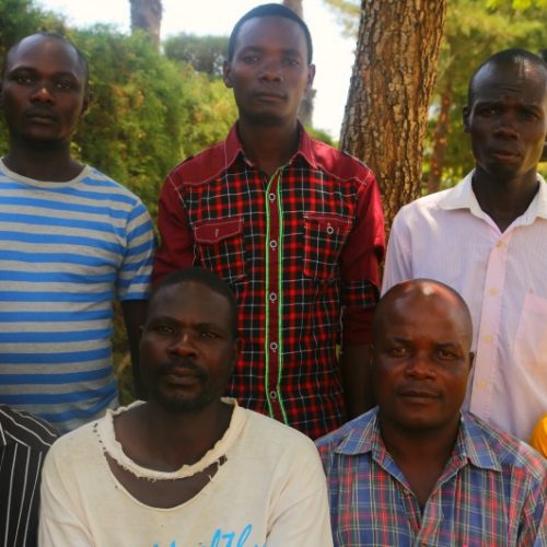 Group of fathers sit outside health centre in Kenya.
