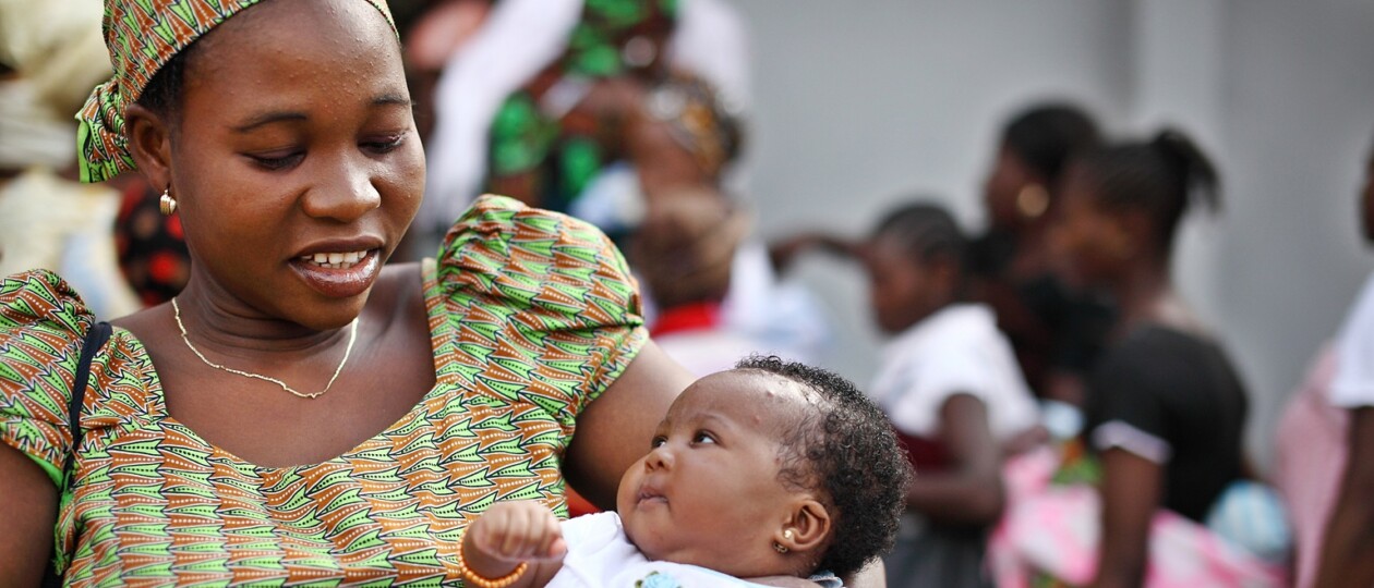 A mom holds her smiling baby in Nigeria