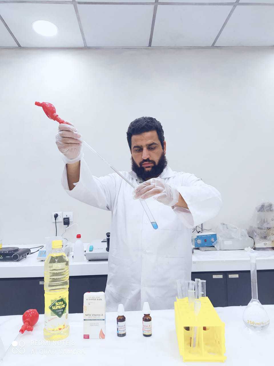 Man in lab coat conducting a vitamin test to check adequacy of fortification in oil