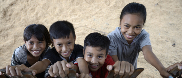 two girls and two boys in Indonesia looking up and smiling