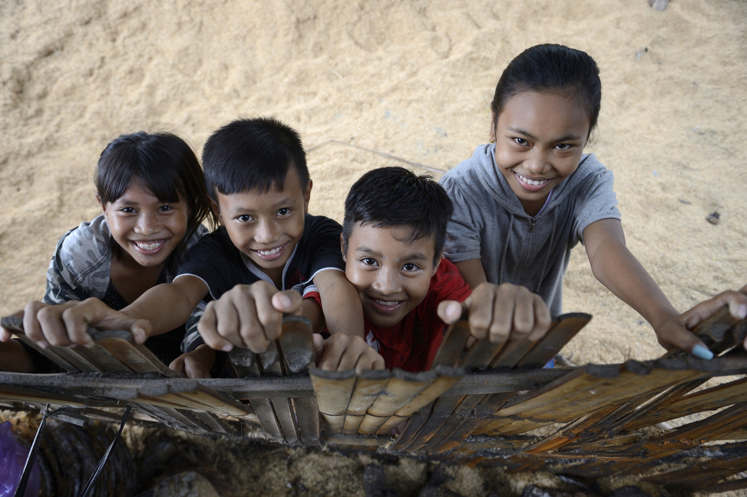 two girls and two boys in Indonesia looking up and smiling