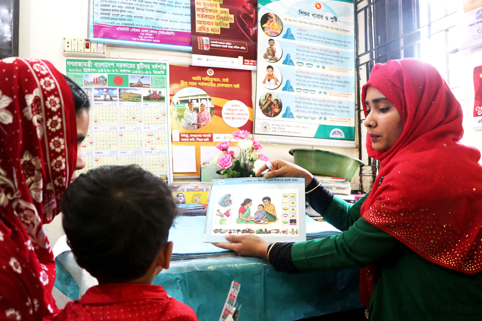 health worker in Bangladesh uses educational materials to explain the importance of health and hygiene to a mother and child
