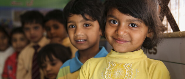 Pakistan boys and girls smiling standing in row in classroom