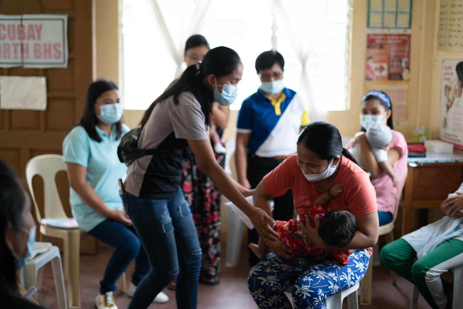 A mother demonstrates different holds for breastfeeding during a peer support group in the Philippines