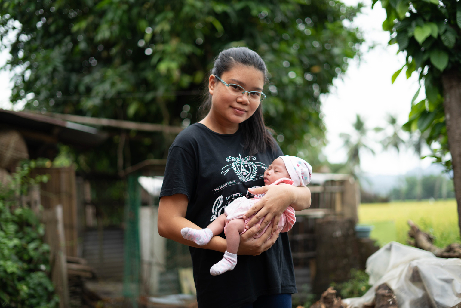 A mother holds her baby in her arms 