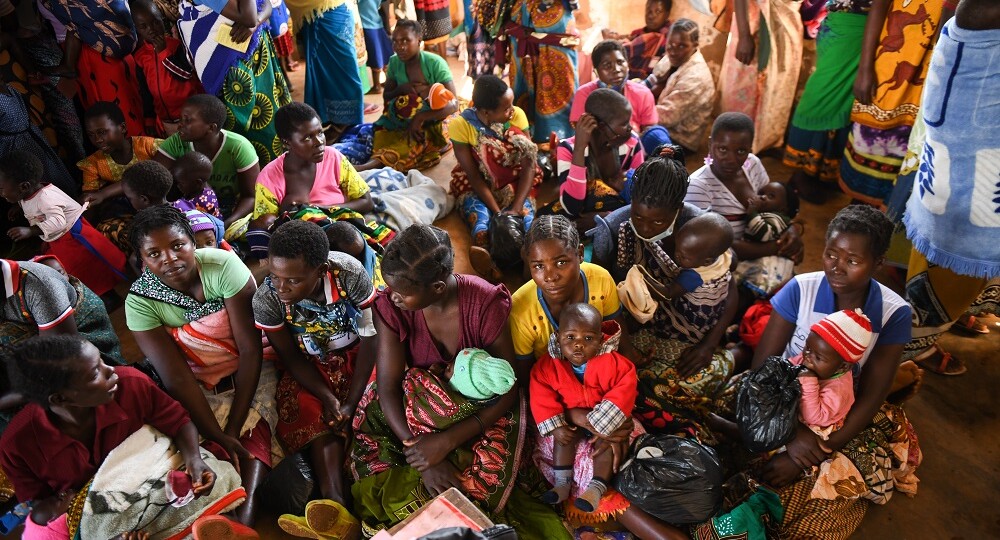 Women hold their children inside a clinic waiting to receive vitamin A supplementation in Malawi