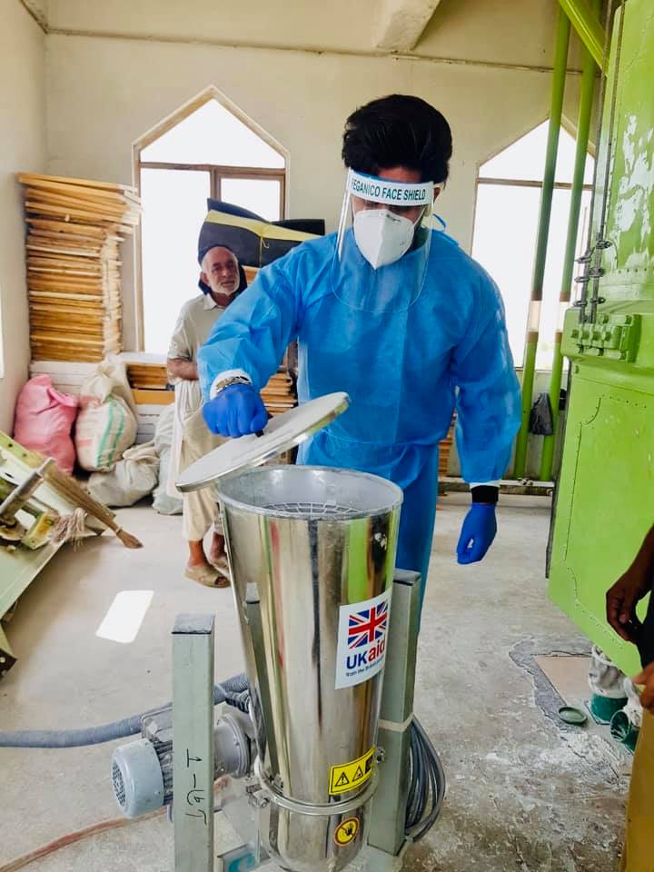 A man in a PPE checking fortification premix stock availability at a processing plant in Pakistan