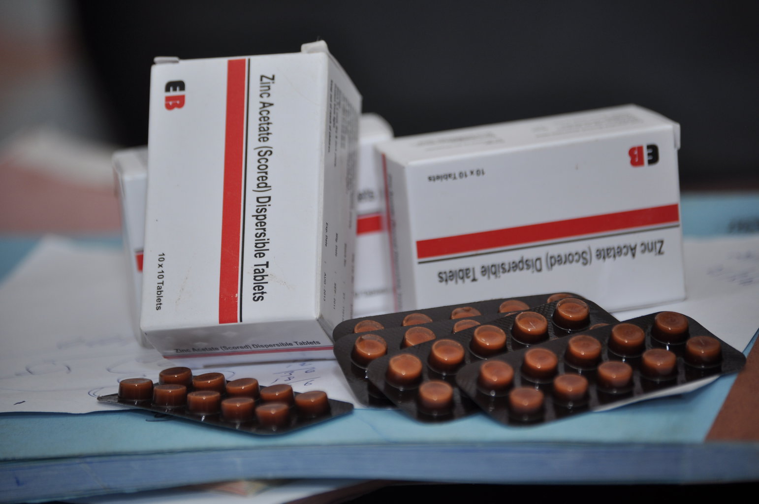 Packages of zinc tablets rest on a table.