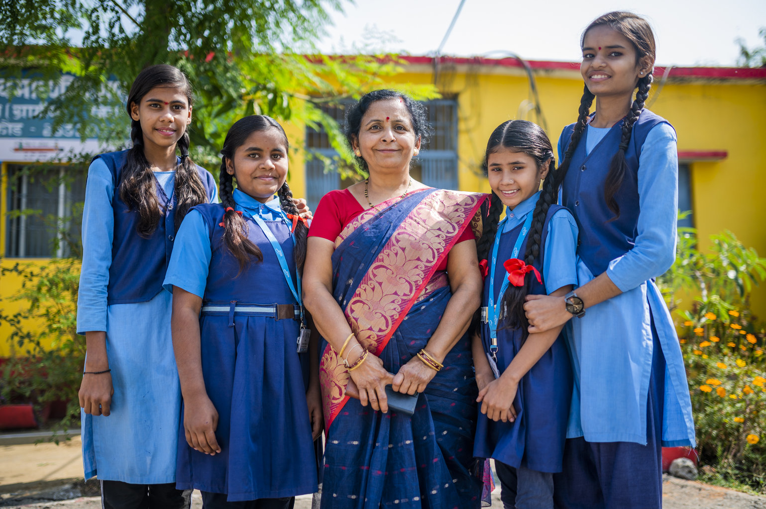 A woman and four adolescent girls stand 