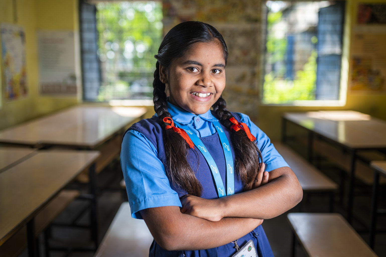 Adolescent girl smiling with her arms crossed