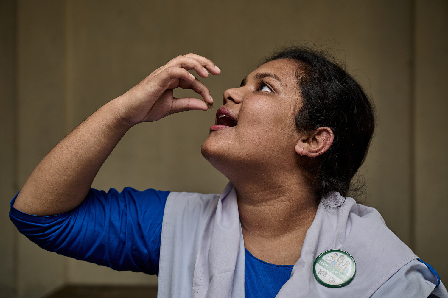 An adolescent girl in a school uniform is consuming an iron and folic acid weekly. 