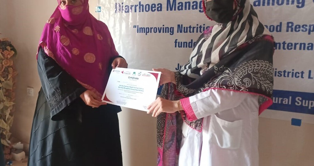 A health worker is presented with a certificate for completing training to effectively treat diarrhoea in children under five.