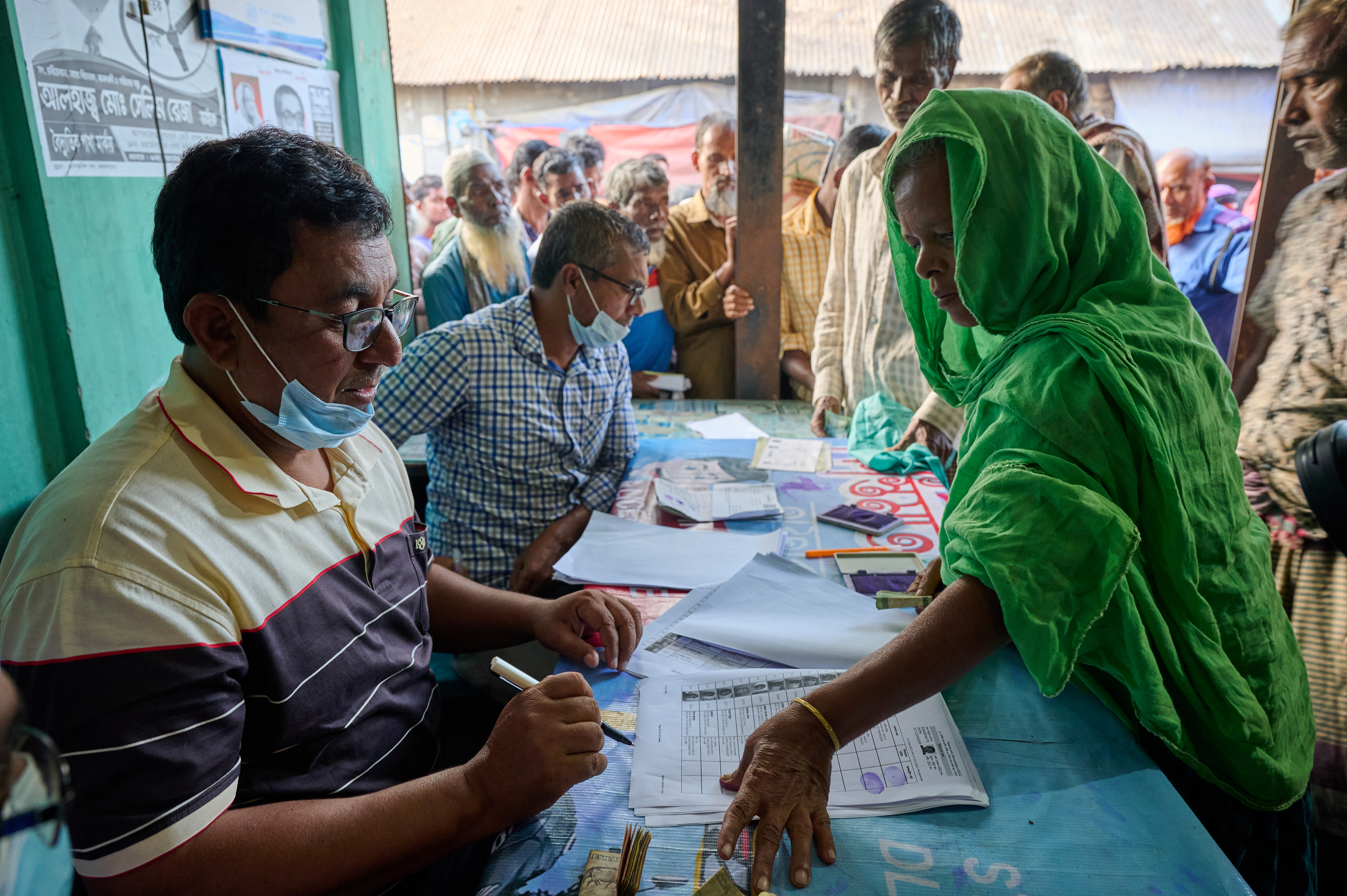 A woman registers at a distribution point to purchase fortified rice at a subsidized price through the Food Friendly Program in Bangladesh. 