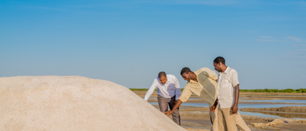 Three men assess a mound of salt to be fortified with iodine in Meatu, Tanzania.