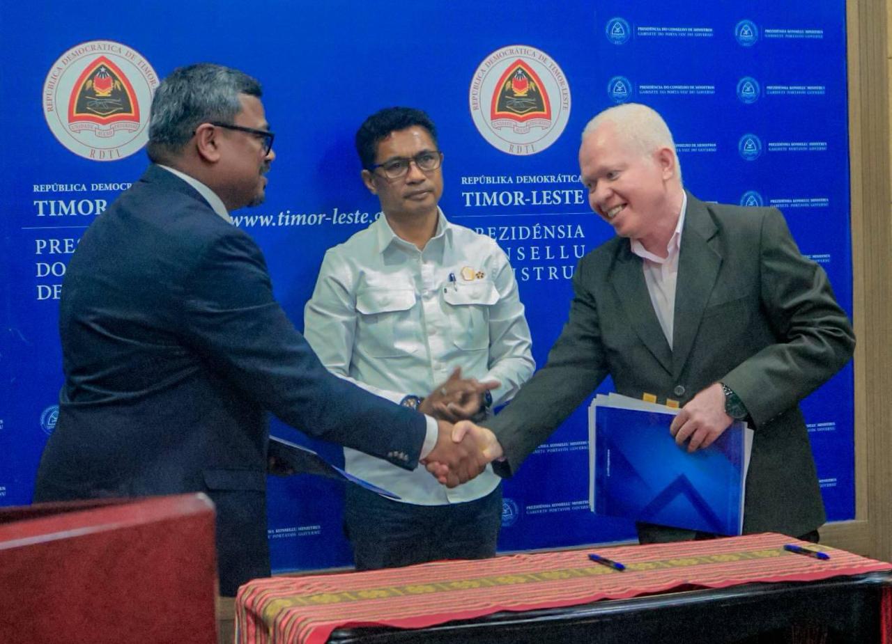 Officials shake hands at the MoU signing in Timor-Leste