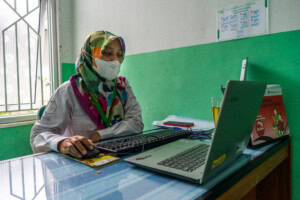 Tita Rosita sitting at desk using laptop