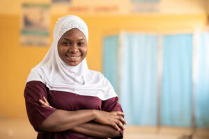 Aisha Jibril standing with arms folded smiling at camera