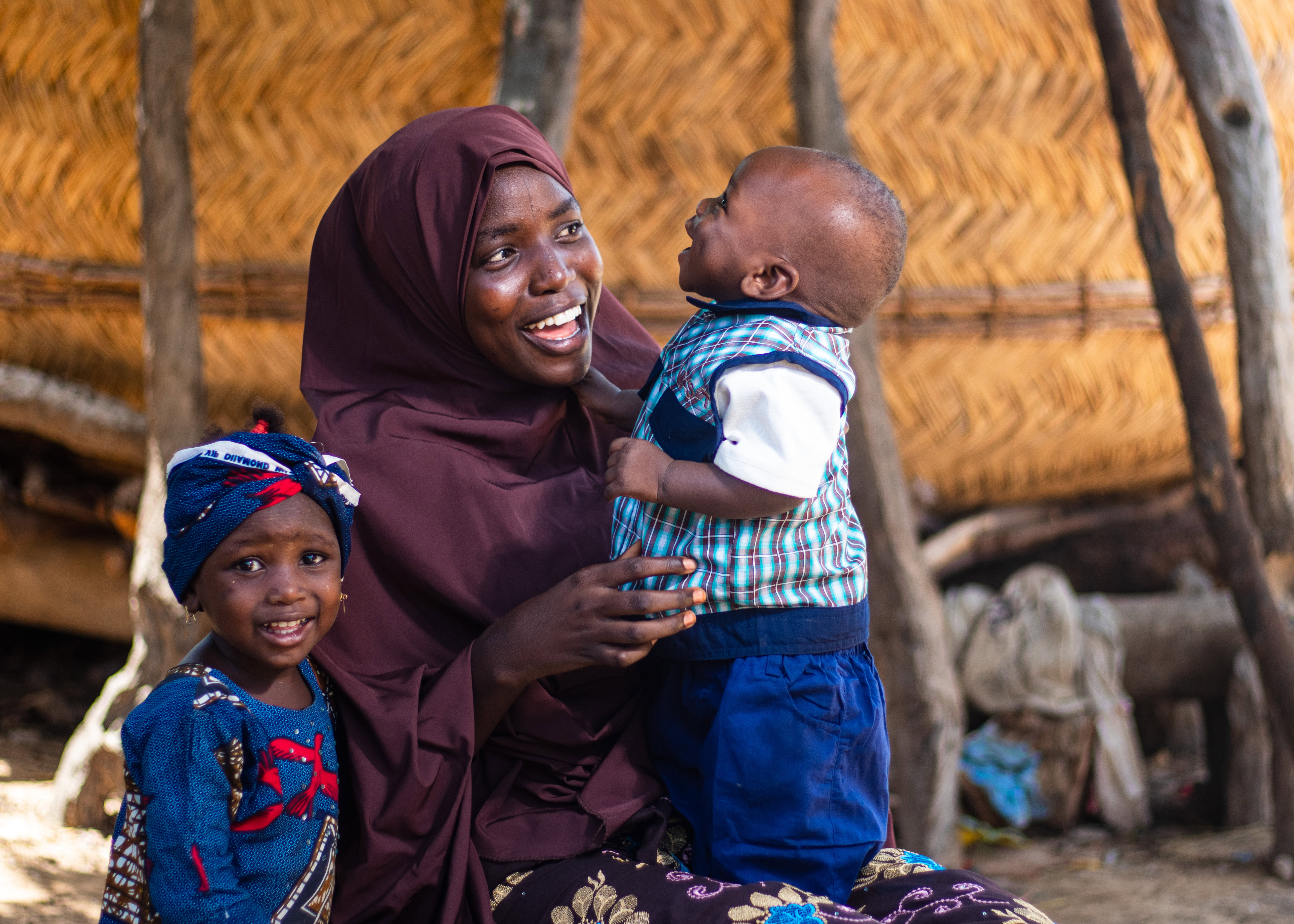 A woman holds her baby looking away from the camera